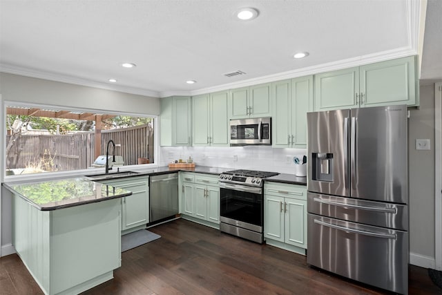 kitchen with visible vents, a sink, stainless steel appliances, a peninsula, and green cabinets