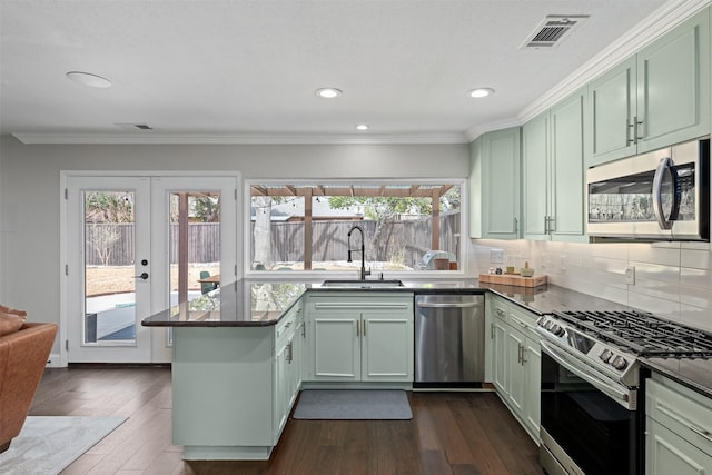 kitchen featuring a sink, visible vents, appliances with stainless steel finishes, and green cabinetry