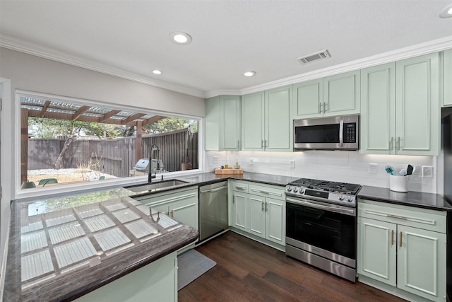 kitchen with dark countertops, visible vents, stainless steel appliances, and a sink