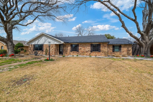 ranch-style house featuring brick siding, a front yard, and a shingled roof