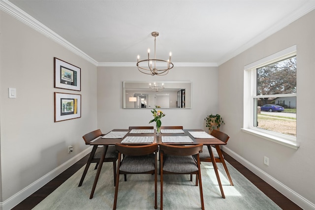 dining space featuring dark wood-style floors, a chandelier, baseboards, and ornamental molding