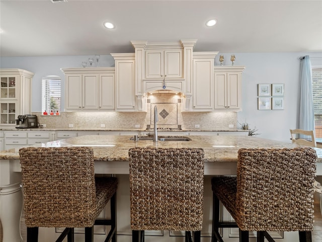1504 Cayman Dr, Allen, TX 75013 - kitchen with a sink, cream cabinets, light stone counters, plenty of natural light, and recessed lighting