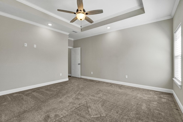 spare room featuring visible vents, crown molding, baseboards, carpet floors, and a raised ceiling