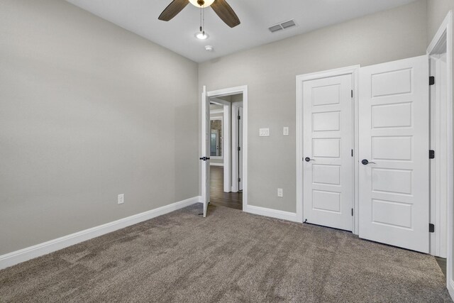 unfurnished bedroom featuring visible vents, baseboards, a ceiling fan, and carpet flooring