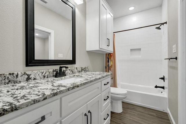 full bathroom with shower / tub combo with curtain, toilet, wood finished floors, and vanity