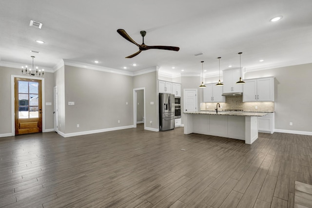 unfurnished living room featuring visible vents, a sink, dark wood-type flooring, crown molding, and ceiling fan with notable chandelier