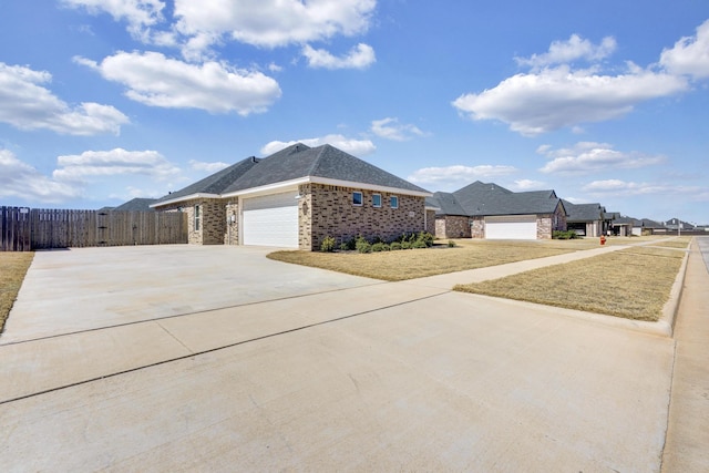 view of property exterior featuring driveway, a gate, fence, a garage, and brick siding