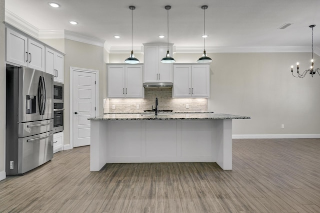 kitchen featuring a sink, under cabinet range hood, backsplash, appliances with stainless steel finishes, and light wood finished floors