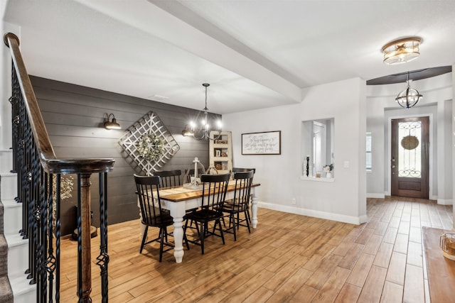 dining space featuring a chandelier, stairway, light wood-type flooring, and baseboards