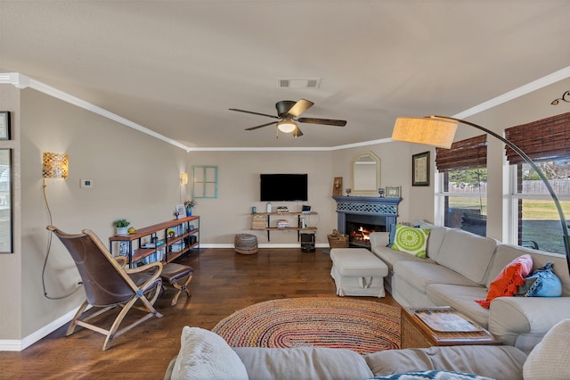 living room with crown molding, wood finished floors, visible vents, and a warm lit fireplace