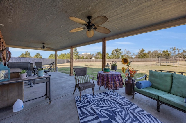 view of patio featuring outdoor lounge area, a trampoline, a fenced backyard, and ceiling fan