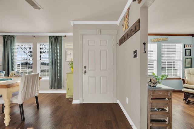 foyer with visible vents, baseboards, ornamental molding, and dark wood-style flooring