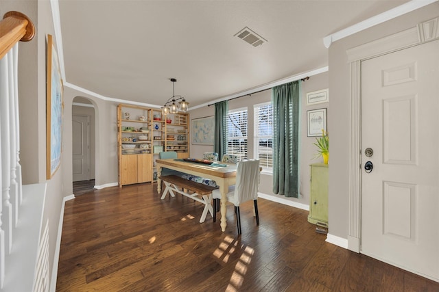 dining room with crown molding, dark wood-style floors, visible vents, and arched walkways