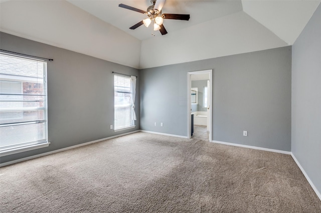 carpeted empty room featuring baseboards, lofted ceiling, and ceiling fan