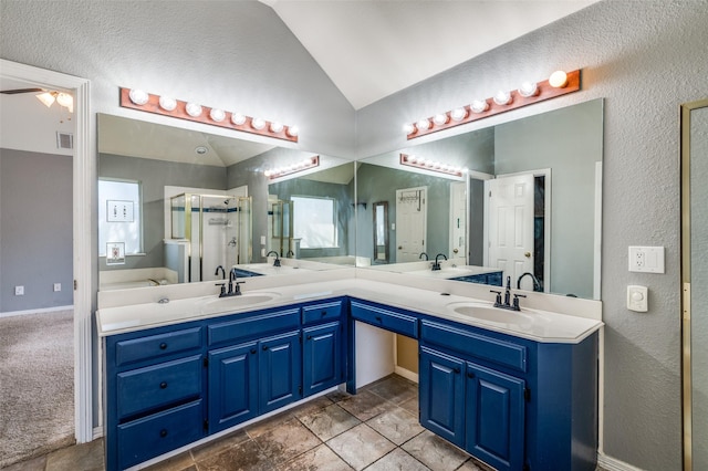 8304 Emerald Cir, North Richland Hills, TX 76180 - bathroom with lofted ceiling, a shower stall, a ceiling fan, double vanity, and a textured wall