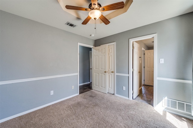 unfurnished bedroom with carpet, visible vents, and baseboards