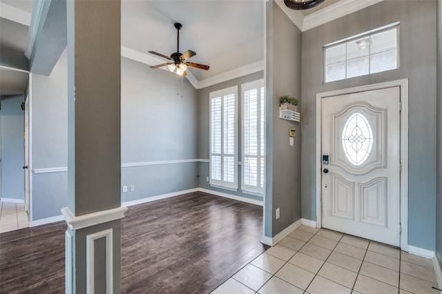 foyer with a ceiling fan, wood finished floors, baseboards, and ornamental molding