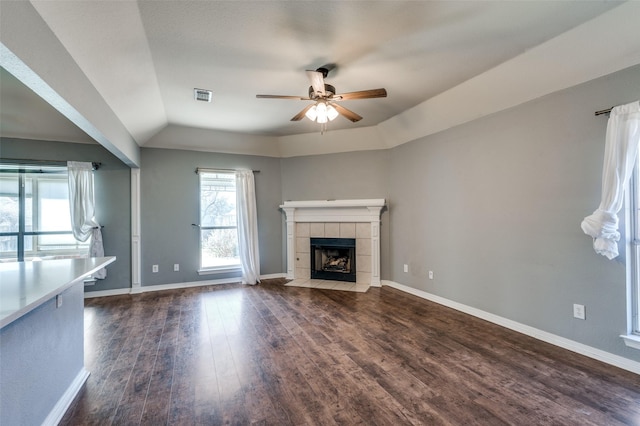8304 Emerald Cir, North Richland Hills, TX 76180 - unfurnished living room featuring ceiling fan, dark wood-type flooring, a tiled fireplace, lofted ceiling, and baseboards