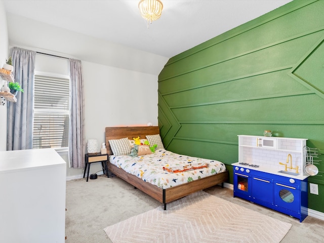 bedroom featuring vaulted ceiling, light colored carpet, and baseboards