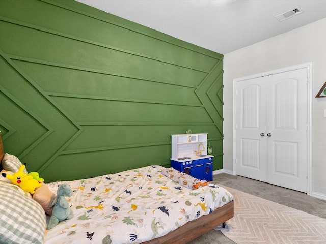 carpeted bedroom with a closet and visible vents