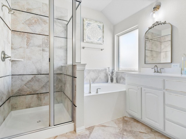 bathroom with vanity, a bath, a shower stall, and vaulted ceiling