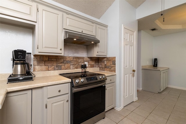 kitchen with light countertops, light tile patterned floors, stainless steel electric stove, and under cabinet range hood