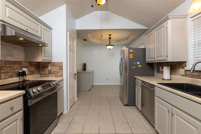 kitchen featuring under cabinet range hood, light countertops, appliances with stainless steel finishes, a raised ceiling, and a sink