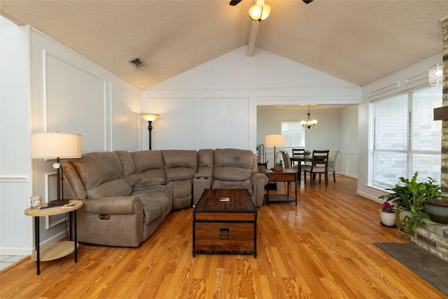 living room featuring a decorative wall, a healthy amount of sunlight, and visible vents