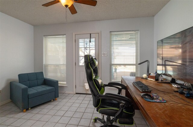 office area featuring ceiling fan, light tile patterned floors, baseboards, and a textured ceiling