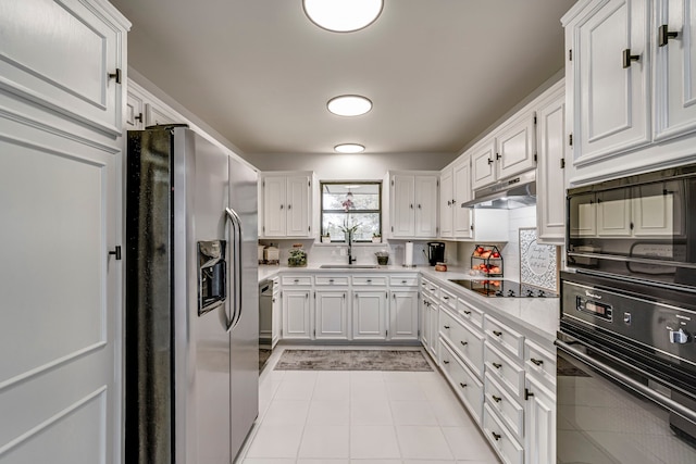 kitchen featuring a sink, black appliances, light countertops, under cabinet range hood, and white cabinetry