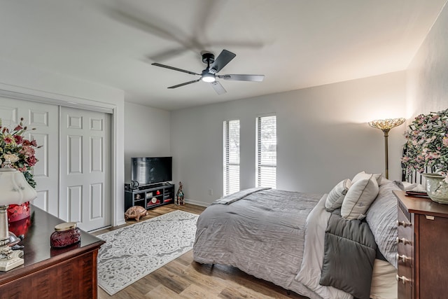 bedroom with a closet, wood finished floors, and a ceiling fan