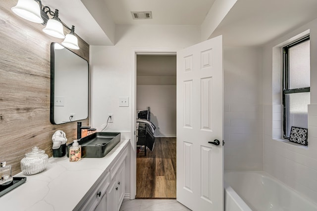 full bathroom featuring visible vents, vanity, and wood finished floors