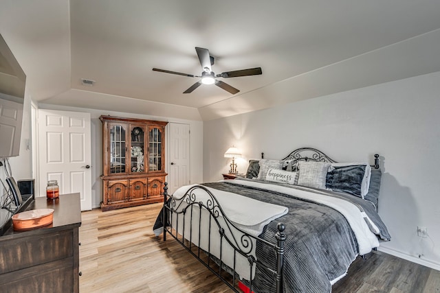 bedroom featuring visible vents, lofted ceiling, ceiling fan, and light wood finished floors