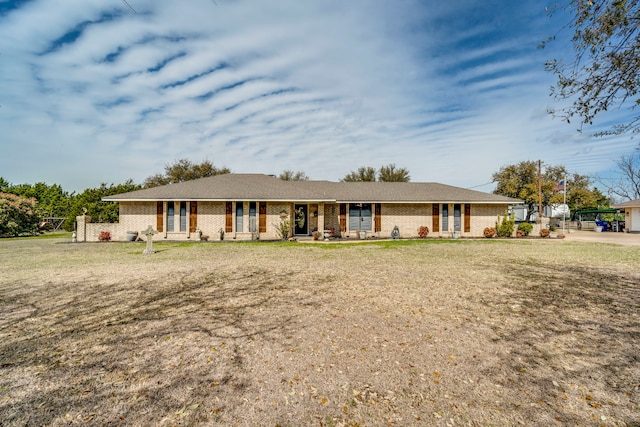 ranch-style house featuring a front yard and brick siding