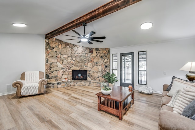 living room featuring a fireplace, lofted ceiling with beams, baseboards, and wood finished floors