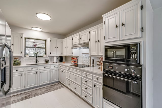 kitchen featuring a sink, black appliances, light countertops, under cabinet range hood, and white cabinetry