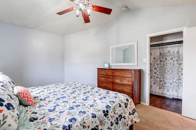 carpeted bedroom featuring a textured ceiling, a ceiling fan, and vaulted ceiling