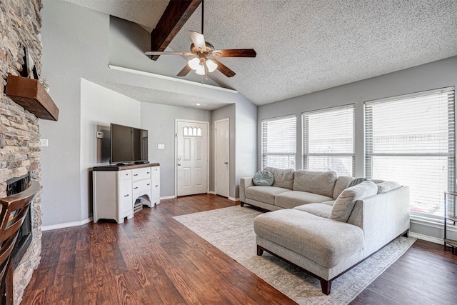 living room featuring dark wood finished floors, a fireplace, a textured ceiling, and lofted ceiling