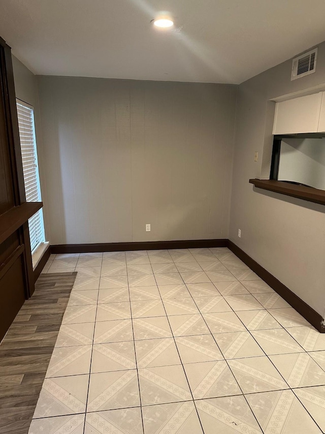 spare room with visible vents, baseboards, and light tile patterned flooring