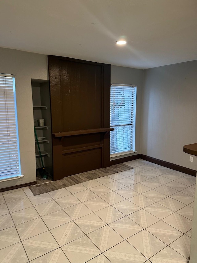 empty room with light tile patterned floors and baseboards