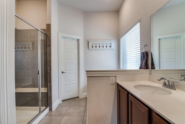 full bathroom with a stall shower, tile patterned flooring, and vanity