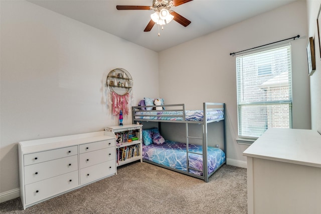 bedroom featuring light colored carpet, baseboards, and ceiling fan