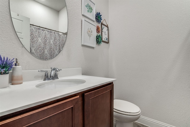 full bath featuring toilet, vanity, and curtained shower