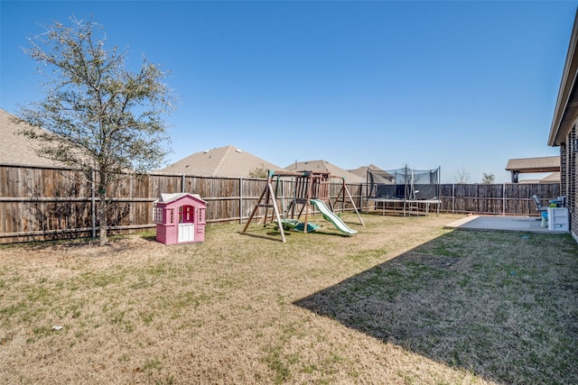 view of yard with a patio, a playground, a trampoline, and a fenced backyard