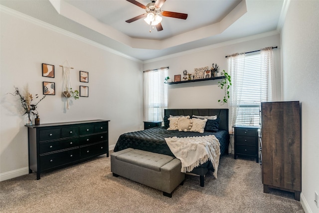 bedroom with a tray ceiling, carpet, baseboards, and crown molding