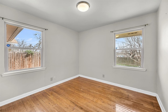 unfurnished room with light wood-style flooring and baseboards