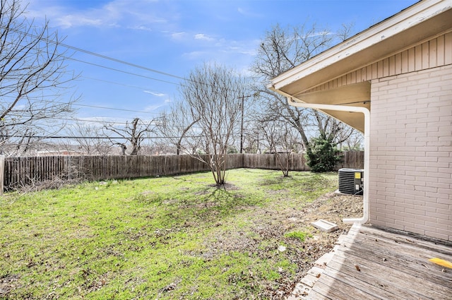 view of yard with a fenced backyard and central AC