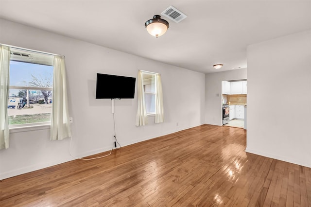 unfurnished living room with visible vents and light wood-style floors