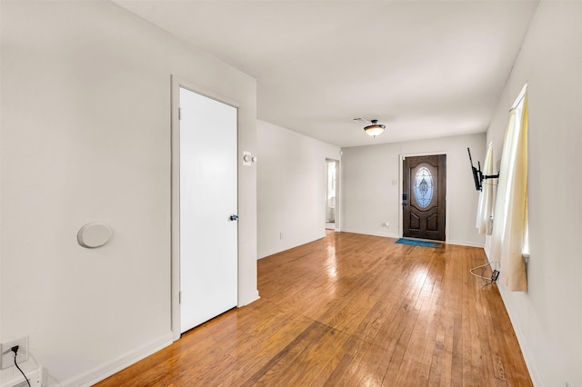 foyer with baseboards and light wood-style flooring