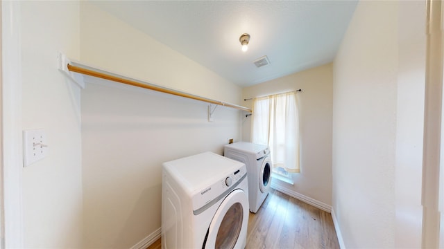 laundry area with light wood-type flooring, visible vents, independent washer and dryer, baseboards, and laundry area